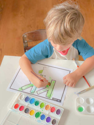 Child painting letters.  Learn through play