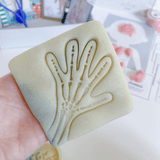 Child holding a hand‑shaped playdough cutter from the Human Body kit.