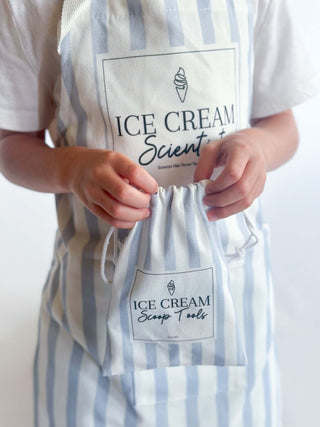 Child holding a blue striped apron and pouch labeled