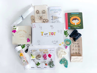 Backyard camping kit for kids with binoculars, compass, homemade playdough, playdough cutter, flower press, lantern craft, and