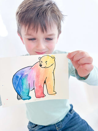 Child using watercolor set to paint animal scenes from hibernation kit