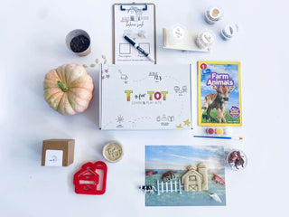 Farm-themed play kit for kids with homemade non-toxic playdough, barn playdough cutter, and a playdough farm mat. Comes with farm animals, a fence, and a balance scale for weighing farm items. Includes