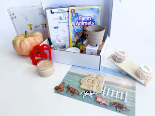 Farm-themed kit for kids with homemade playdough, barn playdough cutter, and farm animals with a fence. Features a balance scale for weighing farm items, a Grow Your Own Pumpkin kit, and a clipboard with farm activities. Includes