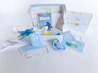 Airplane play and learn kit for kids, featuring supplies to construct and create four different airplanes, including a paper airplane, wooden airplane, straw airplane, and constructed airplane. Comes with homemade playdough, airplane playdough cutter, measuring tape, airplane tickets, passport, and a children