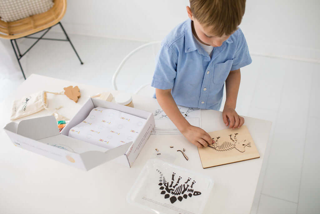 Preschooler completing a dinosaur puzzle as part of a hands-on learning activity