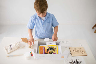Child opening a dinosaur learning kit for hands-on preschool exploration