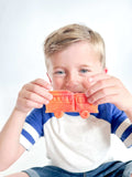 Community Helpers educational kit for kids aged 3-6. Includes dental x-rays, fire engine playdough cutter, homemade playdough, library card rhyming game, Clothesline Clues book, and mailbag with postcards for interactive play.